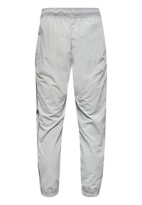 Jasnoszare spodnie dresowe z elastycznym pasem i mankietami, czarny pasek boczny, pokazane od tyłu na białym tle.