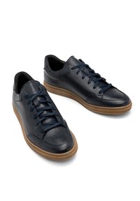 Adidași din piele bleumarin cu o suprafață texturată, design cu șnururi și talpă din cauciuc maro. Vârf rotunjit și estetică minimalistă.