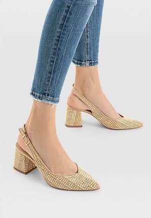 Beżowe plecione sandały na obcasie typu slingback z noskiem w szpic i teksturowaną powierzchnią, wyposażone w masywny, blokowy obcas oraz regulowany pasek wokół kostki.
