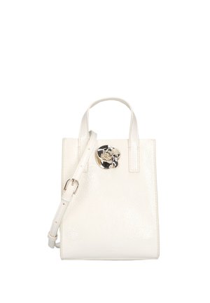 Sac à main en cuir blanc avec doubles poignées, une longue bandoulière réglable et un détail décoratif de fleur argentée au centre avant.