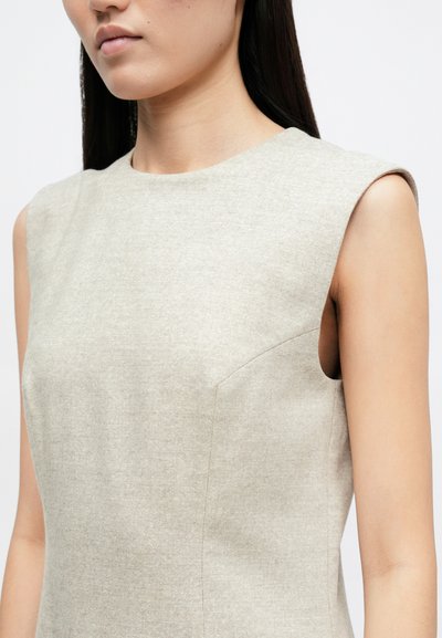 Μπεζ αμάνικο φόρεμα με ψηλό λαιμό, φτιαγμένο από υφασμάτινη υφή, με πλευρικές ραφές και εφαρμοστή σχεδίαση.