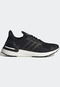 Chaussure de course en maille noire avec des rayures noires, des lacets noirs, un soutien du talon et une semelle blanche texturée sur fond gris clair.