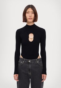 Schwarzer gerippter Strick-Bodysuit mit langen Ärmeln, der mit einer Schlüsselaugen-Aussparung verziert ist, die drei Perlen trägt. Kombiniert mit dunklen Jeans.