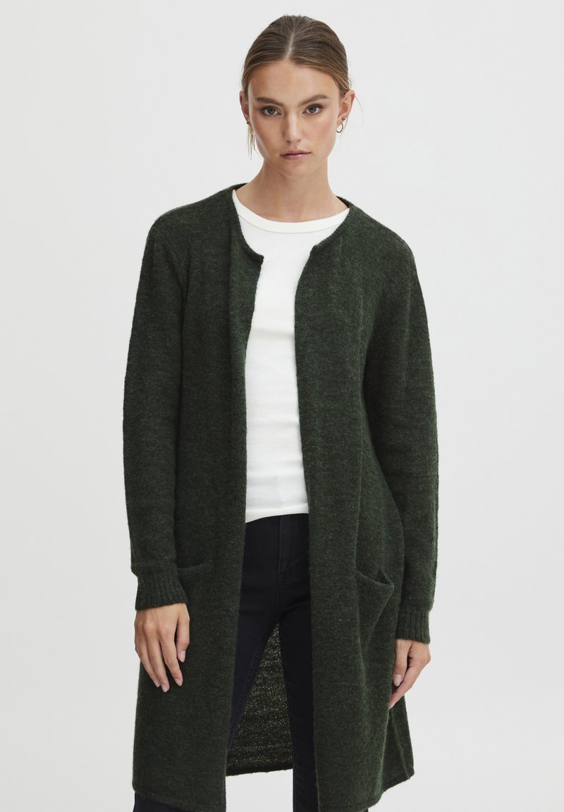 Long cardigan vert en mailles texturées, avec un col rond, une ouverture sur le devant, deux poches latérales et des poignets côtelés.