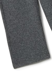 Primo piano della gamba di un pantalone in tessuto grigio scuro testurizzato con cuciture evidenti lungo il bordo su sfondo bianco.