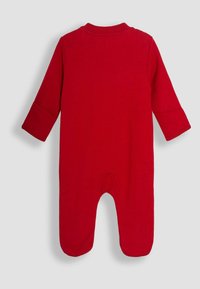 Jumpsuit de algodón rojo con mangas largas, escote redondo y diseño con pies, que cuenta con un cierre a presión en la parte inferior. Textura suave.