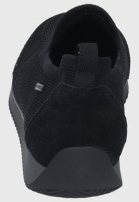 Schwarzer Sneaker mit Obermaterial aus Textil und geripptem Muster. Wildleder-Heelpanel und ein Ziehsteg. Dicke Gummisohle für guten Halt.