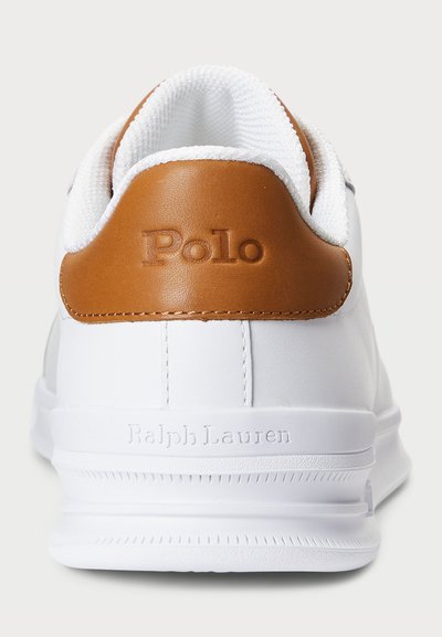 Hvit sneakers med teksturert skinnøvre, brun skinnaccent ved hælen, og preget "Polo" og "Ralph Lauren" logoer.