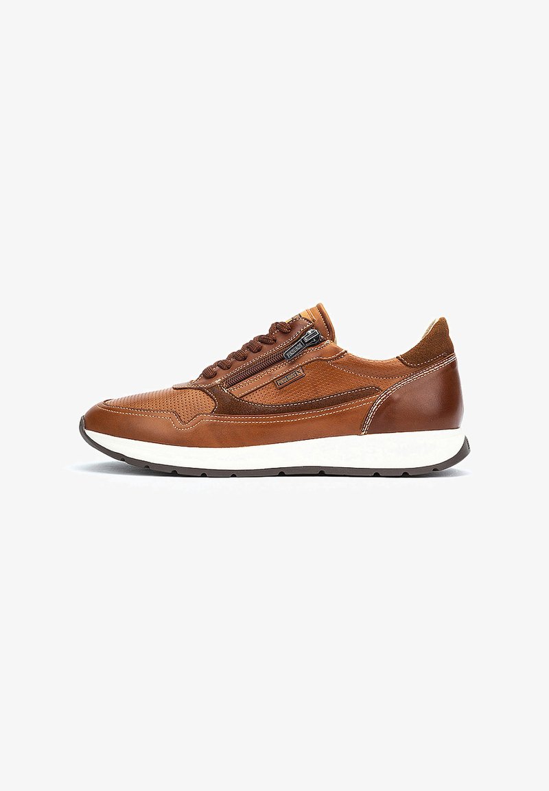 Sneaker in pelle marrone con design perforato, cuciture a contrasto e zip laterale. Suola intermedia bianca e suola esterna in gomma nera.