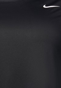 Cămășă sport Nike neagră, confecționată dintr-un material ușor și elastic, cu un croi slim, textură subtilă și un mic logo alb pe piept.
