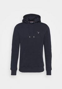 Felpa blu navy con tasca frontale a marsupio, cordoncini sul cappuccio, polsini a coste e piccolo logo bianco sul lato sinistro del petto.