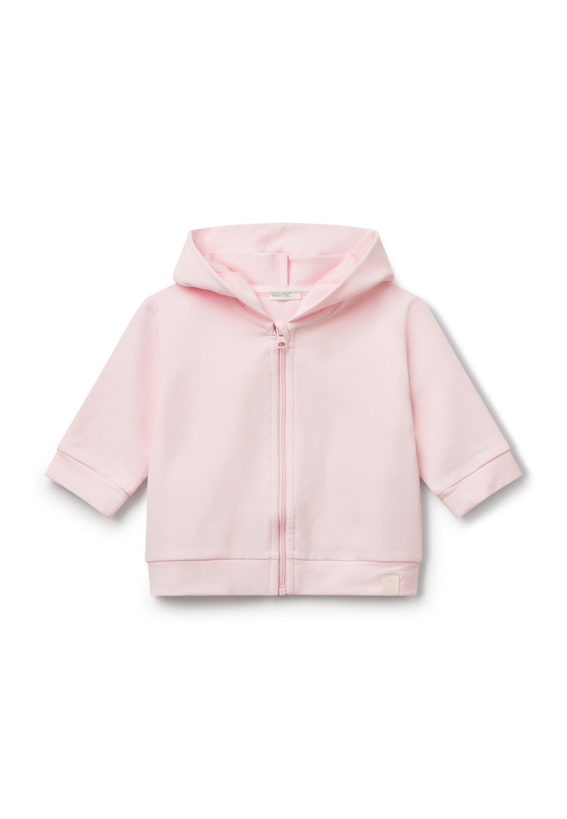 Světle růžová mikina na zip vyrobená z měkké látky. Má kapuci, krátké rukávy a malou logovou nášivku na lemu. Jednoduchý a minimalistický design.