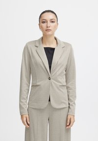 Beige houndstooth patterned blazer with a single button closure and notched lapels, featuring two front pockets and a tailored fit.