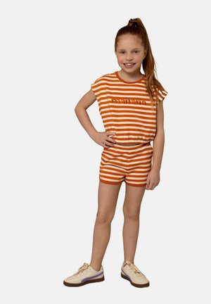 Oranje en witte gestreepte katoenen short set met een gebogen zoom, waarop het woord "mañana" in oranje borduursel is te zien. Gecombineerd met beige sneakers.