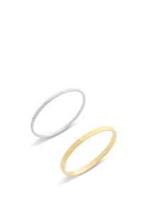 Par de pulseras: una de plata con pequeños cristales transparentes, una de oro con el nombre de la marca grabado. Ambas tienen un diseño delicado y suave.