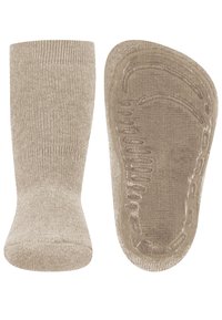 Beige gestrickte rutschfeste Socken mit strukturierten Grip-Mustern an der Sohle, entworfen für den Indoor-Bereich und Sicherheit.