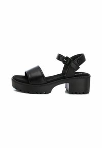 Sandalias de plataforma de cuero negro con una banda ancha en los dedos, correa de tobillo ajustable y suela de goma texturizada.