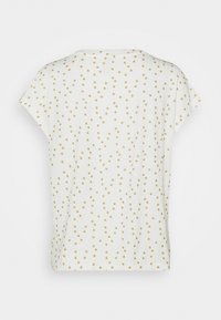 Camiseta blanca de manga corta, con un patrón de pequeños puntos dorados en toda la prenda para aportar textura e interés visual. Cuello redondo simple.