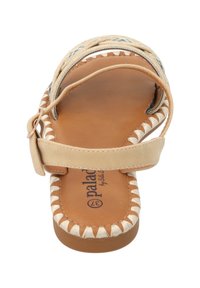 Beige sandaal met bandontwerp, geweven textuur en decoratieve stiksel. Gladde binnenzool en verstelbare gesp-sluiting. Platte zool.