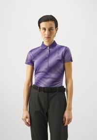 Lilla polo shirt med en teksturert stripete mønster, korte ermer og krage, kombinert med svarte bukser og et vevd belte.