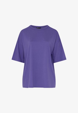 Lilla oversized kortærmet bomulds-T-shirt med rund hals og synligt sort mærkat indeni kraven.