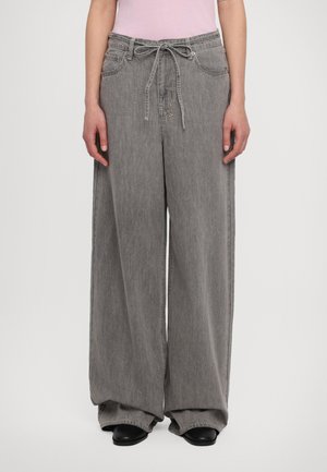 Wide-leg gray denim trousers with a drawstring waist, side pockets, and a relaxed fit. Smooth texture with minimal stitching details.