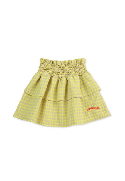 Jupe en vichy jaune avec une taille smockée et trois niveaux de volants. Elle présente un texte brodé rouge en bas à droite.