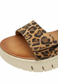 Sandale à bout ouvert avec semelle beige épaisse et large bride imprimée léopard présentant une couture en zigzag sur le dessus.