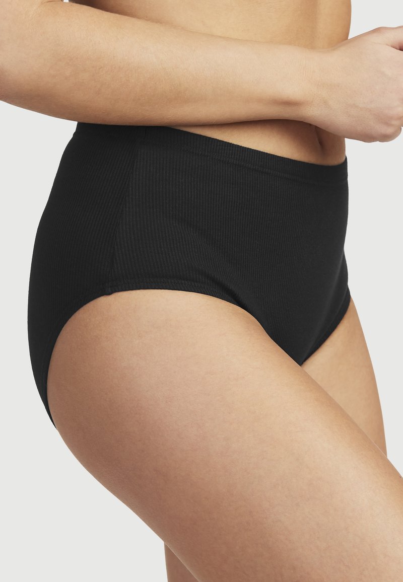 Högmidjade svarta räfflade trosor med en slät yta och elastisk midja, utformade för komfort och täckning.