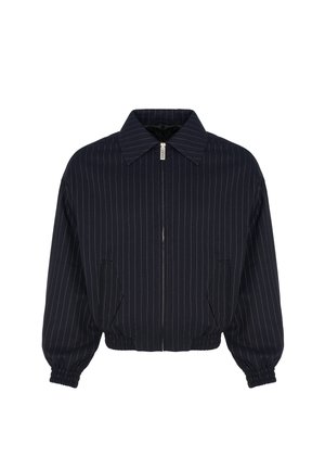 Veste bleu marine zippée avec fines rayures blanches verticales, poignets et ourlet élastiques, col large et deux poches avant.