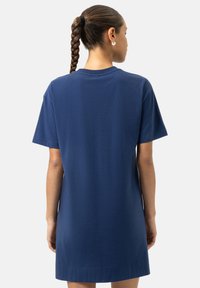 Robe T-shirt en coton bleu marine avec manches courtes, coupe décontractée et encolure ronde. Elle présente une longueur mi-cuisse avec un ourlet droit.