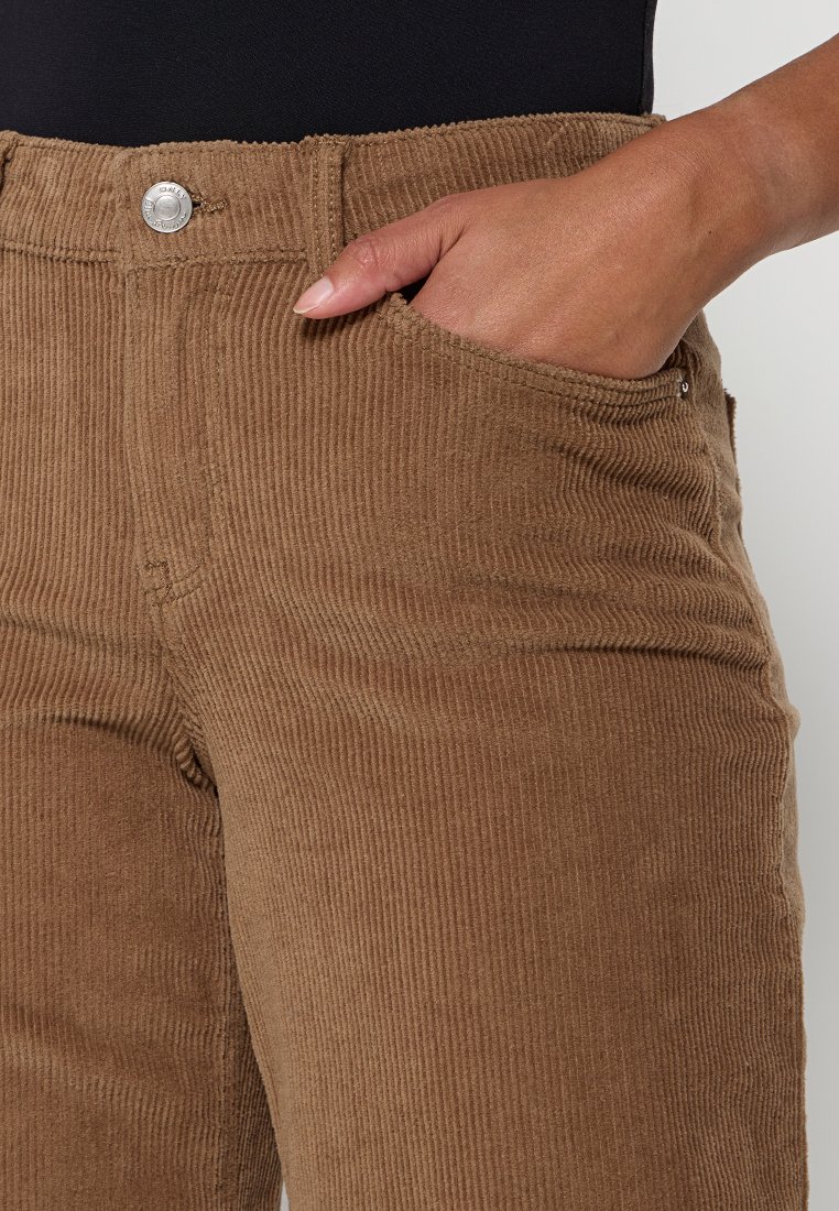 Pantaloni in corduroy marrone con texture a coste verticali, dotati di una tasca frontale e chiusura con bottone silver in vita.