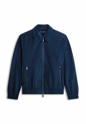 Lichtgewicht jasje in marineblauw met een volledige ritssluiting aan de voorkant, twee met ritsen afsluitbare zijzakken, een kraag en elastische manchetten en zoom.