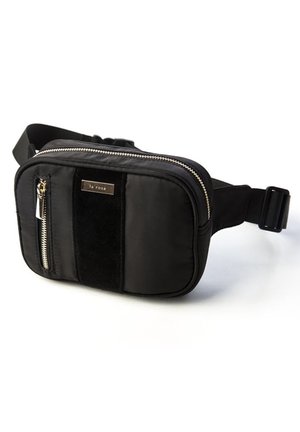 Black nylon fanny pack with a zip closure, featuring a front zip pocket, a soft fabric accent, and a branded metal plate. Adjustable strap included.