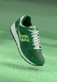 Grønn semsket og mesh sneaker med hvite snører og kontrastfargede lysegrønne detaljer. Har en gummisåle og teksturert overdel.