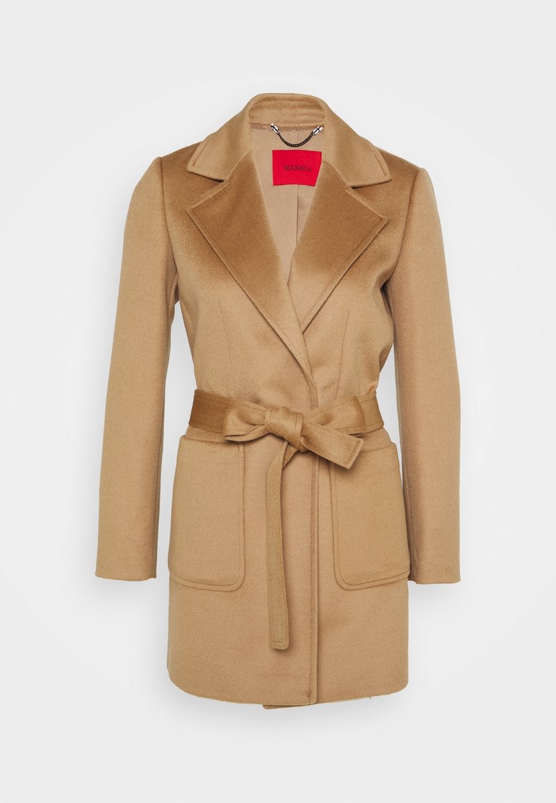 Pehmeästä villasekoitteesta valmistettu tanvyöinen takki, jossa on notched-kaulus, kaksi etutaskua ja solmimisyksityiskohta vyötäröllä. Rakenteellinen siluetti.