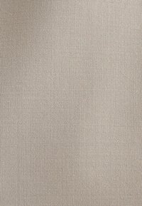 Tissu textured beige avec un tissage fin, présentant un motif subtil. Le matériau semble léger et lisse au toucher.
