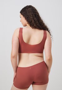Kobberfarget bralette og boyshort-sett med glatt tekstur. Braletten har brede stropper og rund hals; boyshorten har en sømløs design.