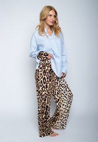 Lichtblauwe gestreepte shirt gecombineerd met leopardprint pyjamabroek. Het shirt heeft een ontspannen pasvorm; de broek is wijduitlopend met verschillende bruintinten.