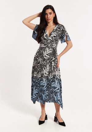 Black and white patterned wrap dress with short flutter sleeves, transitioning to a blue hem. Features a V-neck and a tied waist.