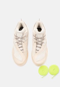 Beige sneakers med en tekstureret, suedelignende overdel, meshdetaljer og lyse snørebånd. To ekstra neongrønne snørebånd inkluderet.