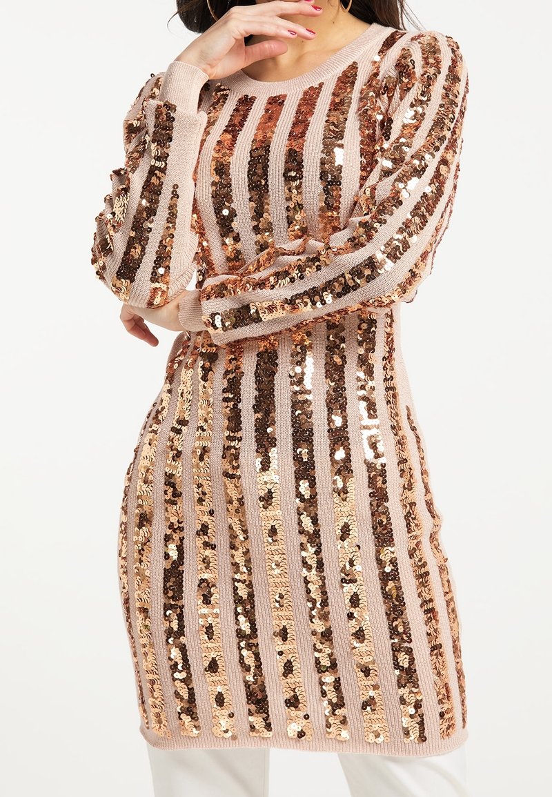 Långärmad stickad klänning med växlande ränder av rosaguld och bronspaljetter på en mjuk beige bas, med en avslappnad passform.