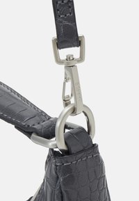 Grå tekstureret lædertaske rem med sølv metal hardware, der har en rektangulær spænde og en drejelig klemme til påsætning.