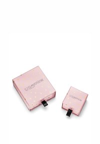 Rozā iepakojuma kastītes divās izmēros, ar zelta sirdīšu rakstu un melnu lentu, uz kuras ir uzraksts "Glanzstücke München".