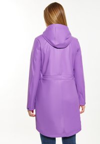 Fioletowy wodoodporny płaszcz z kapturem, zwężoną talią, długimi rękawami i gładką fakturą. Projekt nie zawiera widocznych zapięć ani wzorów.