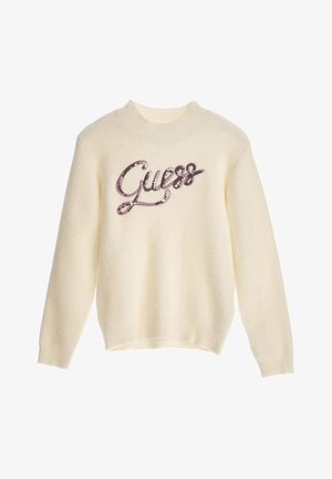 Pull de couleur crème avec un col rond côtelé, arborant un logo "Guess" pailleté en rose et argent sur le devant. Texture douce, manches longues.