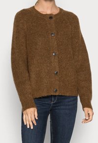 Brun stickad cardigan med rund halsringning, utrustad med sex svarta knappar fram, ribbade ärmslut och nederkant, mjuk textur.