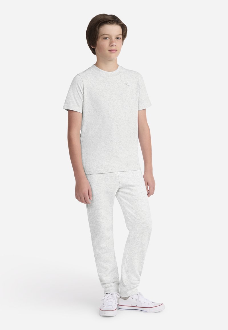 T-shirt gris clair en coton à manches courtes avec col rond, assorti à un pantalon de la même couleur. Les deux ont une texture douce et une coupe décontractée, portés avec des baskets blanches.