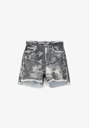 Shorts in denim bianco e nero effetto usurato con toppe scolorite, orli sfrangiati, chiusura anteriore con bottoni e cerniera, e tasche frontali.