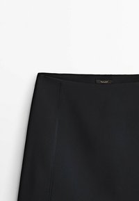 Black pencil skirt with a smooth texture, fitted shape, and subtle stitching details. Features a label near the waistband.